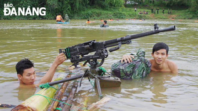 Chiến sĩ Trung đoàn 971 vận chuyển vũ khí vượt sông bằng bè tự tạo trong diễn tập vòng tổng hợp. Ảnh: CÁT TƯỜNG	