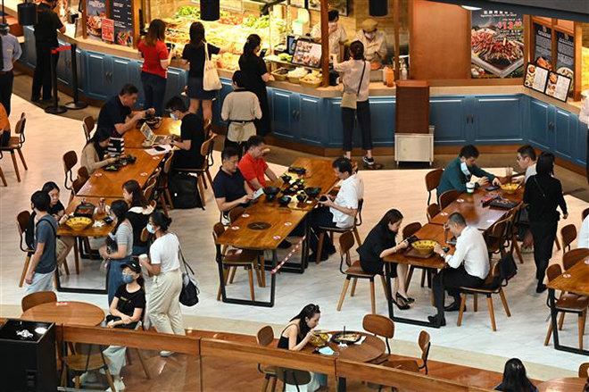 Khách hàng dùng bữa tại một nhà hàng trong trung tâm thương mại ở Singapore. Ảnh: AFP/ TTXVN