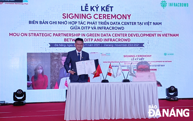 Giám đốc Công ty CP Phát triển khu công nghệ thông tin tập trung Đà Nẵng Nguyễn Anh Huy ký kết hợp tác đầu trực tuyến với đối tác Singapore. Ảnh: TRIỆU TÙNG 