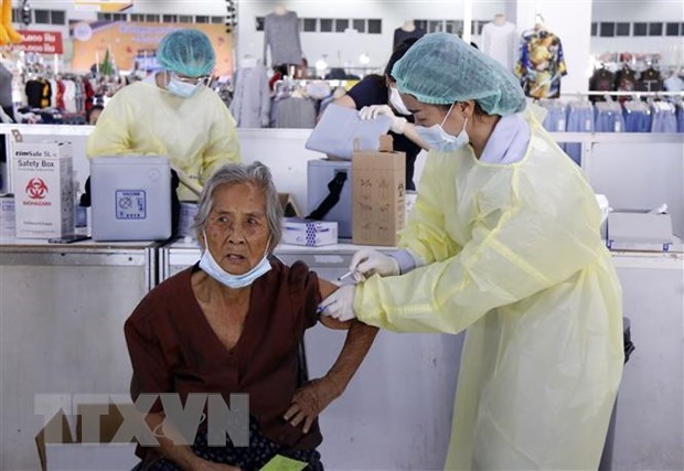 A health worker gives a COVID-19 shot to a senior citizen in Vientiane (Photo: VNA)
