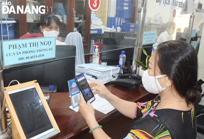 Người dân tiến hành quét mã VNPay QR để thanh toán phí, lệ phí tại UBND phường Thanh Bình. Ảnh: HOÀNG HIỆP