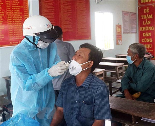 A health worker collects nasal swab from a man for COVID-19 testing. (Photo: VNA)