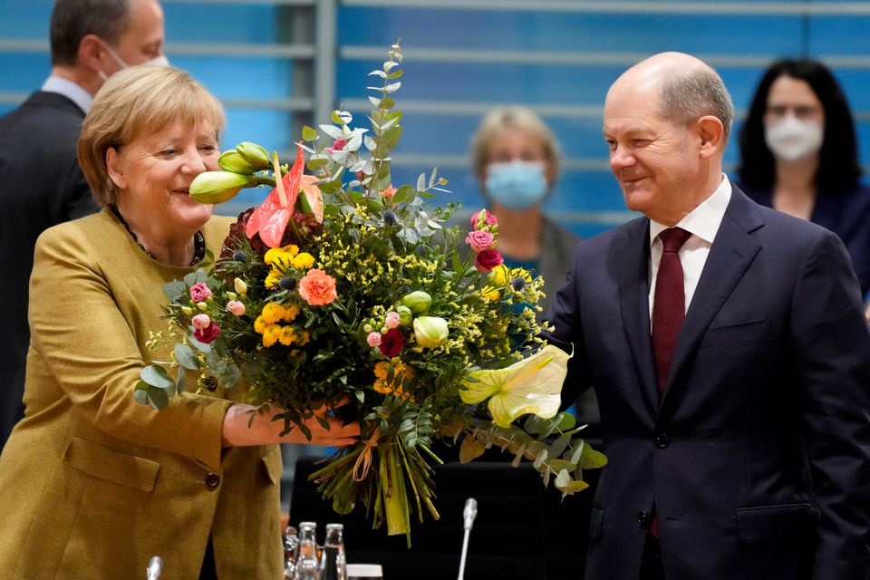 Thủ tướng Đức Angela Merkel (trái) nhận hoa từ Phó Thủ tướng kiêm Bộ trưởng Tài chính Olaf Scholz khi có thông tin 3 đảng đạt được thỏa thuận thành lập chính phủ liên minh. Ảnh: Reuters