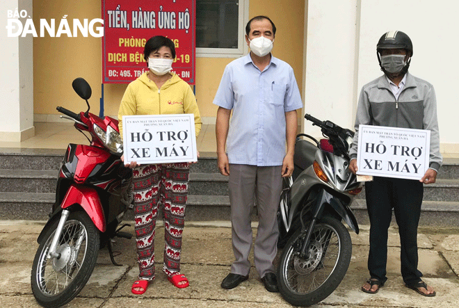 Đại diện Ủy ban MTTQ Việt Nam phường Xuân Hà (giữa) trao xe máy cho 2 hộ ông  Trần Văn Vinh (phải) và bà Nguyễn Thị Bích Thủy trong năm 2021. Ảnh: LÊ VĂN THƠM