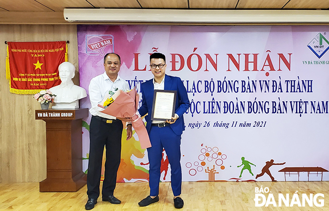 A leader of the Viet Nam Table Tennis Federation (left) handing over the establishment decision to a representative of the VN Da Thanh Table Tennis Club. Photo: TAN LOC