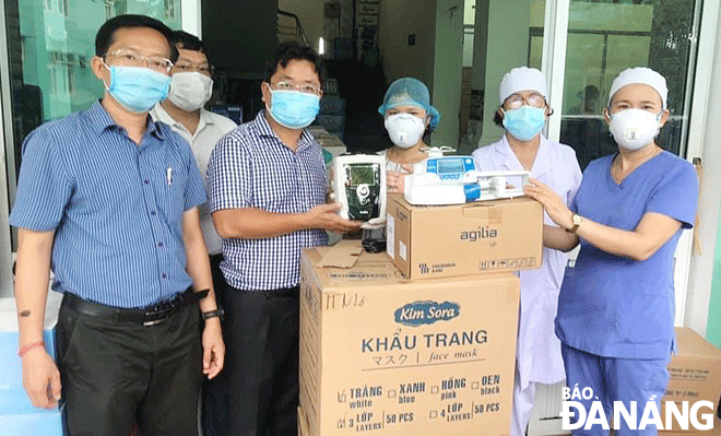  Mr Ha Duc Hung (left cover), Chairman of the Da Nang Young Entrepreneurs Association in its 6th term, presented medical equipment donated by the Association to the Hoa Vang District Medical Centre in August 2020. Photo: M.QUE