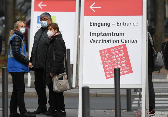  Người dân chờ tiêm vaccine phòng Covid-19 tại một trung tâm tiêm chủng ở Frankfurt, Đức ngày 25-11-2021. Ảnh: THX/TTXVN