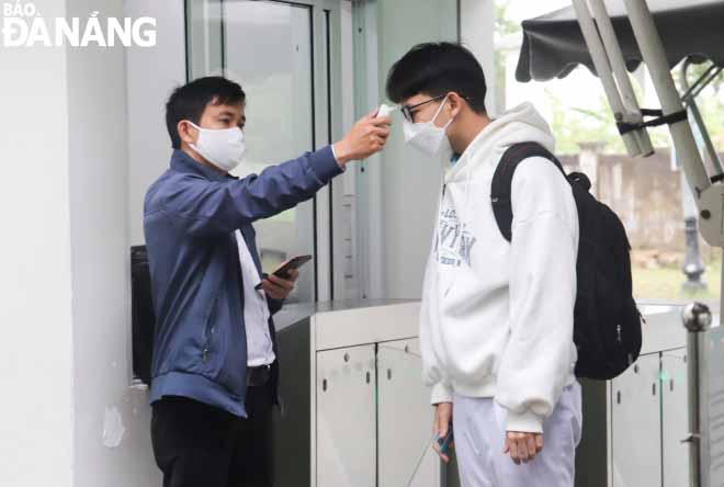 Students of Skyline School have their body temperature checked at the school gate.