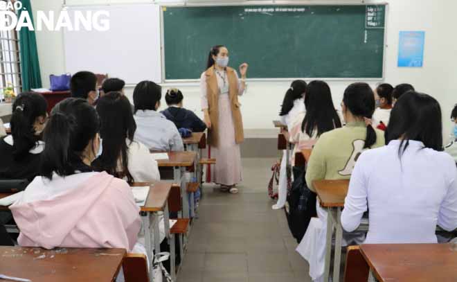 A homeroom teacher introduces precautionary measures to her students at Phan Chau Trinh Senior High School to keep themselves and others safe and healthy during the school year.