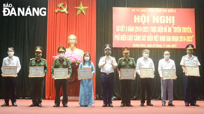 Thiếu tướng, Chính ủy Bộ Tư lệnh Cảnh sát biển Bùi Quốc Oai (giữa) trao bằng khen của Bộ Tư lệnh Cảnh sát biển cho các tập thể, cá nhân có thành tích trong công tác tuyên truyền, phổ biến Luật Cảnh sát biển Việt Nam trong 3 năm (2019-2021). Ảnh: NAM TRUNG	