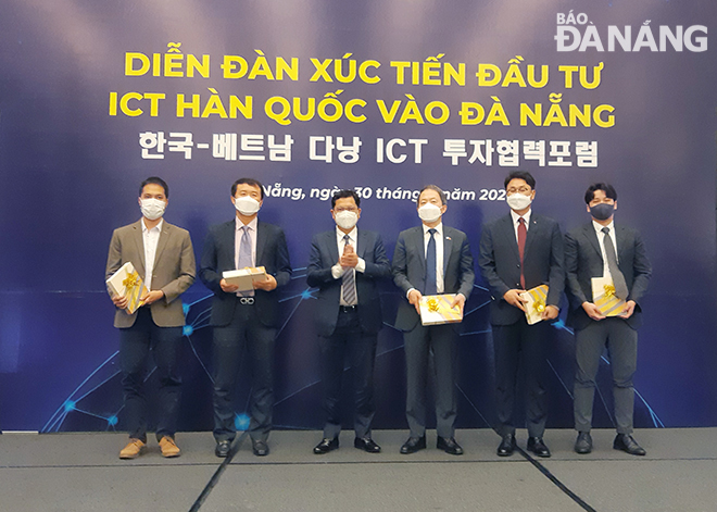 Phó Chủ tịch UBND thành phố Trần Phước Sơn (người thứ 3 từ trái sang) trao quà lưu niệm của thành phố cho các đại biểu tại diễn đàn. Ảnh: THÀNH LÂN 
