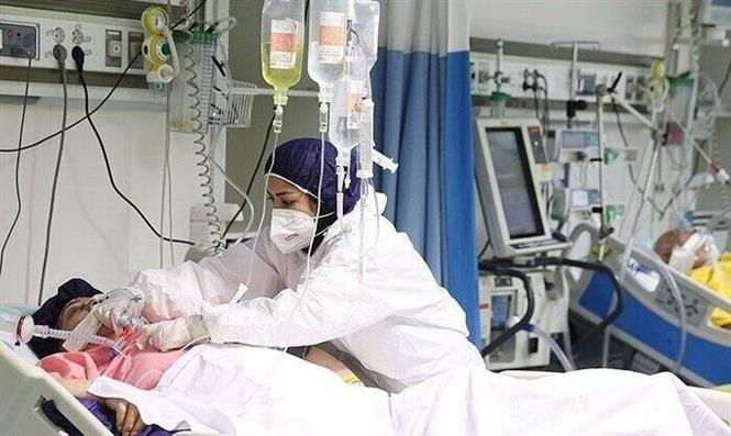 Nhân viên y tế điều trị cho bệnh nhân Covid-19 tại bệnh viện ở Iran. Ảnh: IRNA/ TTXVN
