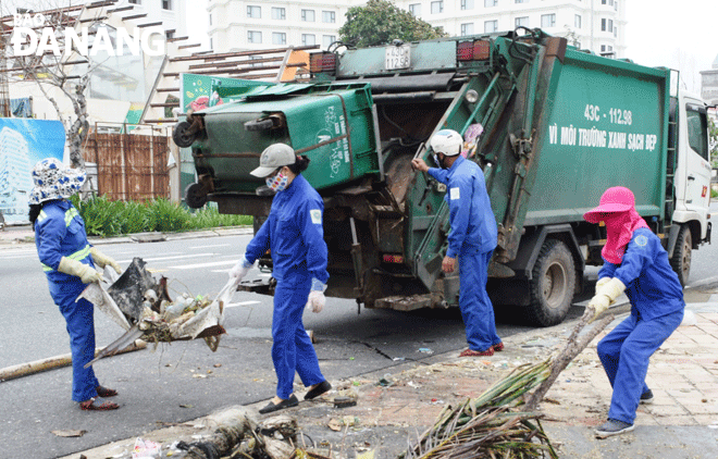 Công nhân Xí nghiệp Môi trường Sơn Trà tập trung thu gom rác, bảo đảm vệ sinh môi trường trên địa bàn. Ảnh: HOÀNG HIỆP