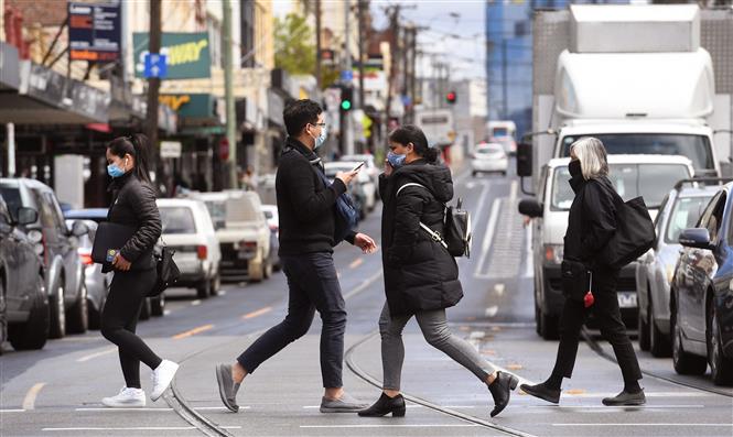 Người dân đeo khẩu trang phòng dịch COVID-19 tại Melbourne, Australia ngày 11/10/2021. Ảnh: AFP/TTXVN