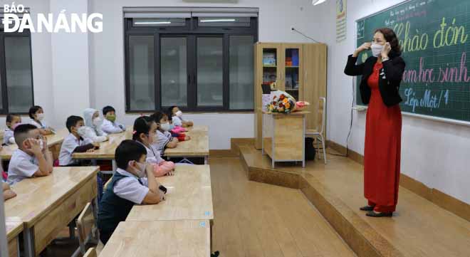 Giáo viên Trường Tiểu học Lý Tự Trọng (quận Hải Châu) dành tiết đầu để hướng dẫn học sinh đeo khẩu trang đúng cách.