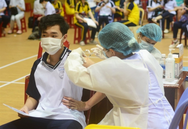 A high school student receives a COVID-19 vaccine shot at Tiên Sơn Stadium, Đà Nẵng, on November 20, 2021. — VNA/VNS Photo Văn Dũng