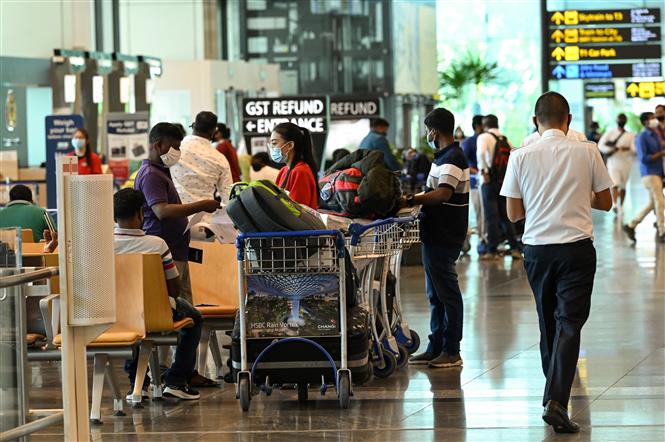 Hành khách đeo khẩu trang phòng dịch Covid-19 tại sân bay quốc tế Changi, Singapore, ngày 15-3-2021. Ảnh: AFP/ TTXVN