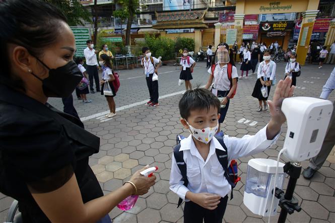 Kiểm tra thân nhiệt cho học sinh để phòng dịch Covid-19 tại trường học ở Phnom Penh, Campuchia, ngày 1-11-2021. Ảnh: THX/ TTXVN