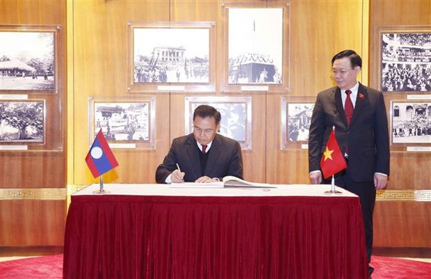 Xaysomphone Phomvihane signs the Golden Book at the Vietnamese National Assembly's traditional room. (Photo: VNA)