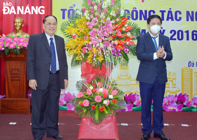 Phó Bí thư Thường trực Thành ủy Lương Nguyễn Minh Triết (phải) tặng hoa Ban Đại diện Hội NCT thành phố. Ảnh: LÊ VĂN THƠM