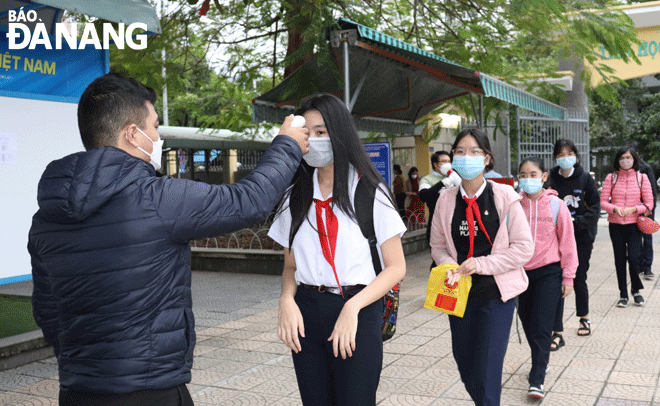 Students at the Nguyen Hue Secondary School in Hai Chau District have their body temperatures taken before entering classrooms. Photo: NGOC HA