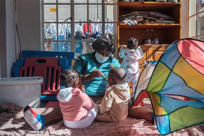 Một y tá chăm sóc trẻ em bị bỏ rơi tại một trung tâm nuôi dưỡng trẻ em có hoàn cảnh khó khăn ở Johannesburg, Nam Phi. Ảnh: AFP/TTXVN