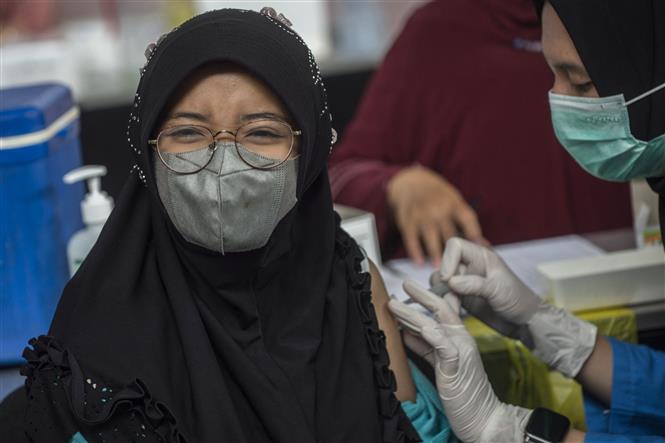 Nhân viên y tế tiêm vaccine ngừa COVID-19 cho người dân tại Surabaya, Indonesia, ngày 23/9/2021. Ảnh: AFP/TTXVN