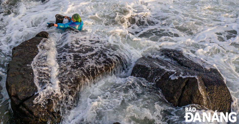 To pick up seaweed, women have to climb up rock cliffs quite far from the shore.