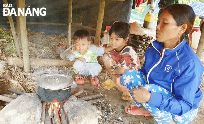 Ms. Dinh Thi Ut prepares meals for her family after hard-working hours. Photo: N.H