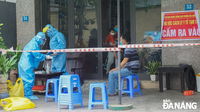 Healthcare workers sealed off a family in Lien Chieu District after one of its members had tested positive for COVID-19, and a warning sign is displayed in the front of this house in order inform others stay away from it. In photo: all members of this family are getting tested for the virus