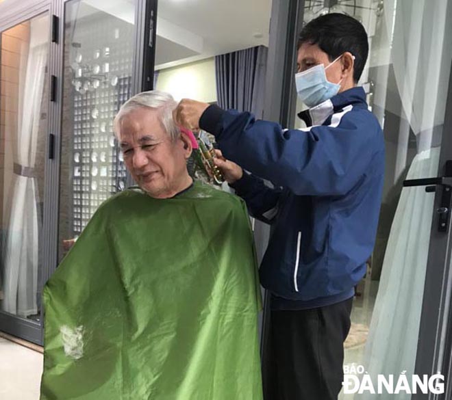 Cựu chiến binh Phạm Công Lương (phải) cắt tóc miễn phí cho người cao tuổi trên địa bàn phường Thuận Phước, quận Hải Châu. Ảnh: LÊ PHƯƠNG