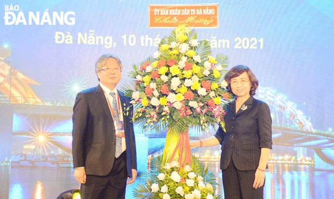 Vice Chairwoman of the Da Nang People's Committee Ngo Thi Kim Yen (right) presenting flowers to congratulate the conference. Photo: THU HA