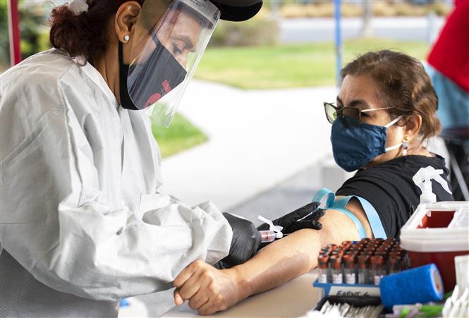 Nhân viên y tế tiêm vaccine phòng Covid-19 cho người dân tại Santa Monica, California, ngày 19-1-2021. Ảnh: AFP/TTXVN