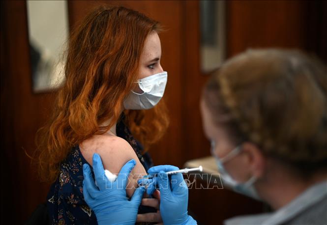 Nhân viên y tế tiêm vaccine Covid-19 cho người dân tại London, Anh ngày 4-12-2021. Ảnh: AFP/TTXVN