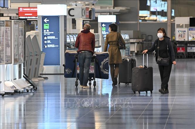 Hành khách tại một sân bay ở Tokyo, Nhật Bản ngày 1-12-2021. Ảnh: AFP/TTXVN