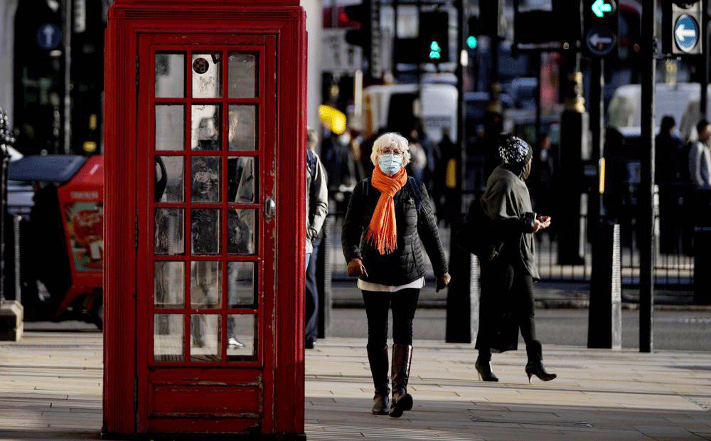 Người dân đeo khẩu trang khi đi lại trên đường phố London (Anh) ngày 9-12. Ảnh: AP