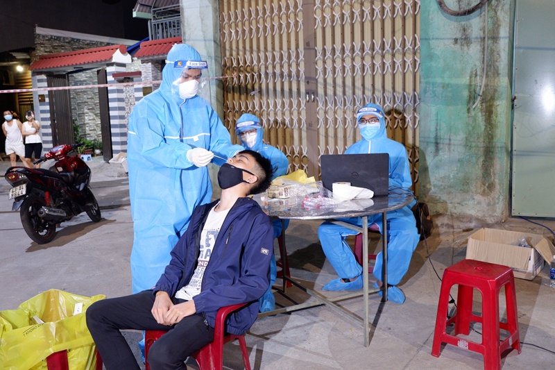 A healthcare worker takes nasal swab sample of a resident in Lien Chieu District