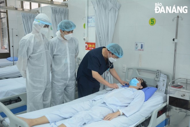 Các bác sĩ Bệnh viện C Đà Nẵng thăm khám cho bệnh nhân T. sau phẫu thuật. Ảnh: L.H