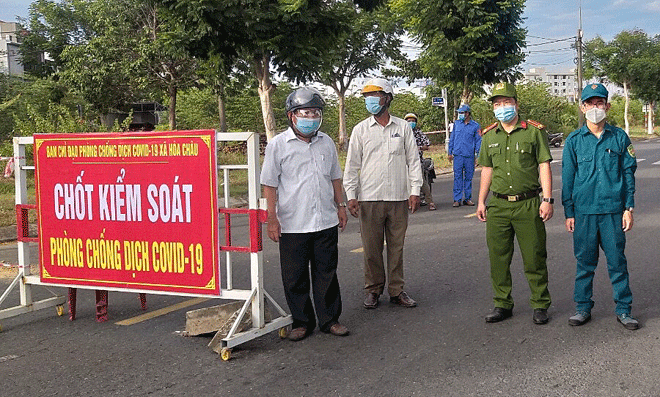 Ông Trần Công Anh (bên trái) cùng lực lượng chức năng xã Hòa Châu tham gia trực chốt trong những ngày dịch bệnh diễn biến phức tạp trong tháng 9-2021. (Ảnh do nhân vật cung cấp)