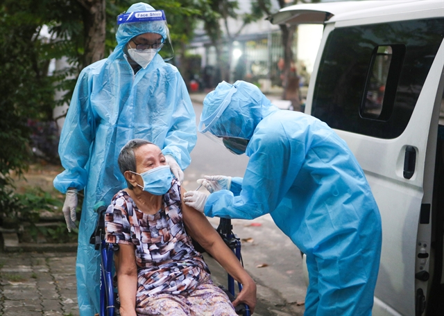 An elderly woman in Đà Nẵng City gets her COVID-19 vaccine from a mobile vaccination team. — VNA/VNS Photo