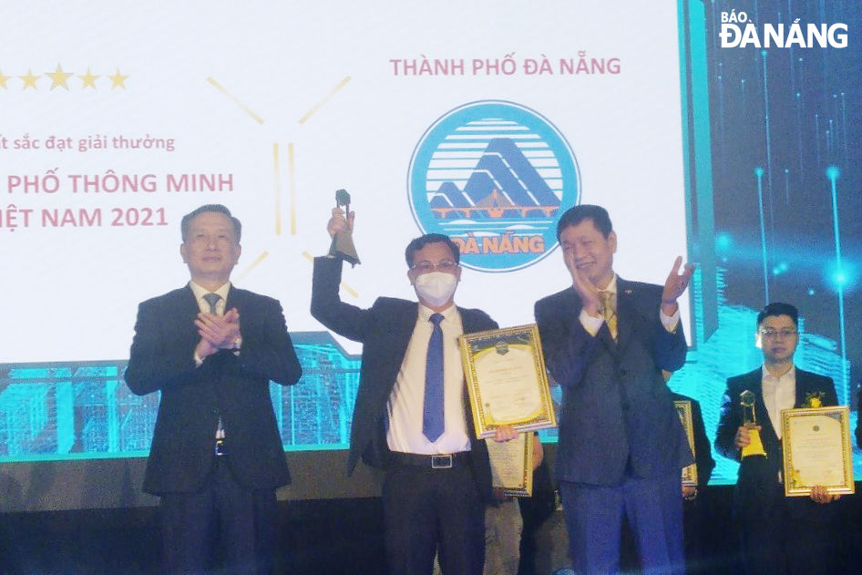 On behalf of the Da Nang authorities and people, Deputy Director of the Da Nang Department of Information and Communications Tran Ngoc Thach (middle) receives the ‘Viet Nam Smart City Award 2020 at the awards ceremony in Ha Noi, December 18, 2021.