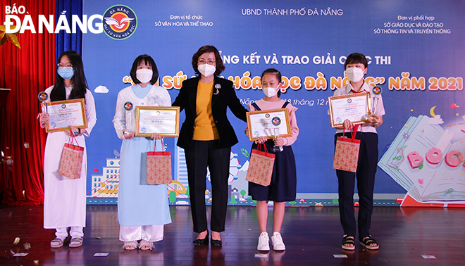 Vice Chairwoman of the Da Nang People's Committee Ngo Thi Kim Yen (centre) honours the four recipients of the ‘Typical Ambassador of Reading Culture’ title, December 18, 2021