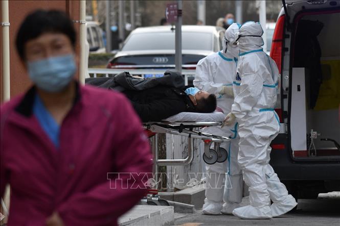 Nhân viên y tế đưa bệnh nhân COVID-19 tới bệnh viện ở Bắc Kinh, Trung Quốc. Ảnh: AFP/ TTXVN