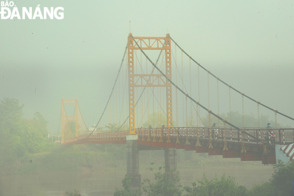 The view of the Kon Klor Suspension Bridge at dawn in foggy conditions