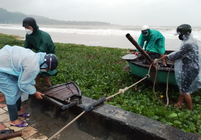 Các ngư dân chuẩn bị đưa thuyền thúng lên tuyến đường Hoàng Sa vì sóng biển đã xâm thực sâu do ảnh hưởng của bão số 9. Ảnh: HOÀNG HIỆP