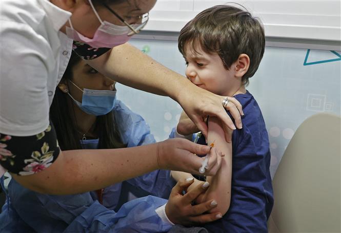 Nhân viên y tế tiêm vaccine phòng Covid-19 cho trẻ em trong độ tuổi từ 5-11 tại Tel Aviv, Israel ngày 22-11-2021. Ảnh: AFP/TTXVN