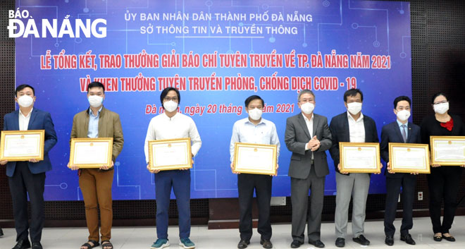 Thừa ủy quyền của Chủ tịch UBND thành phố, Giám đốc Sở Thông tin và Truyền thông thành phố Nguyễn Quang Thanh (thứ 4 phải sang) trao tặng bằng khen cho các tập thể. Ảnh: LÊ HÙNG