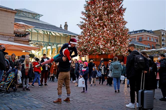 Người dân mua sắm chuẩn bị cho Giáng Sinh tại London, Anh, ngày 18/12/2021. Ảnh: AFP/TTXVN