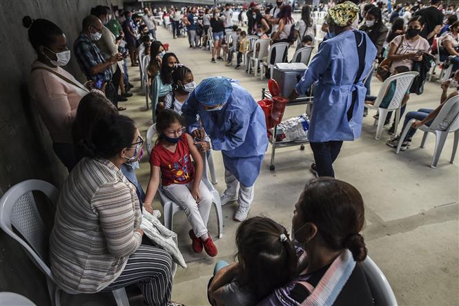  Nhân viên y tế tiêm vaccine phòng Covid-19 cho trẻ em tại Medellin, Colombia, ngày 14-12-2021. Ảnh: AFP/ TTXVN