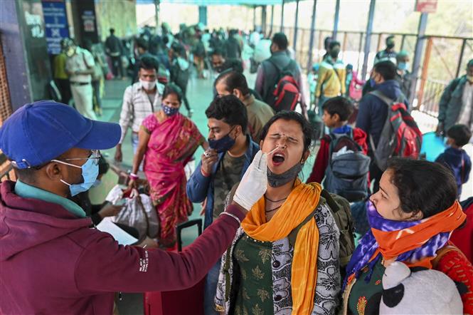  Nhân viên y tế lấy mẫu xét nghiệm Covid-19 tại một nhà ga ở Bangalore, Ấn Độ, ngày 1-12-2021. Ảnh: AFP/TTXVN